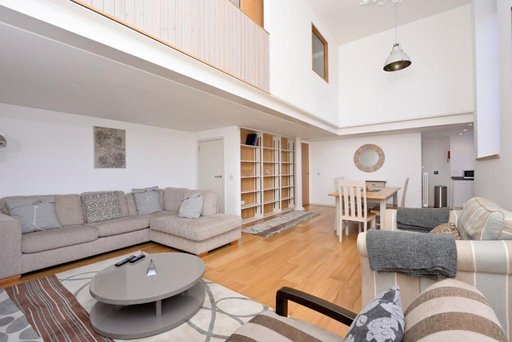 ein Wohnzimmer mit einem Sofa und einem Tisch in der Unterkunft Destiny Scotland - Broughton St Lofts in Edinburgh