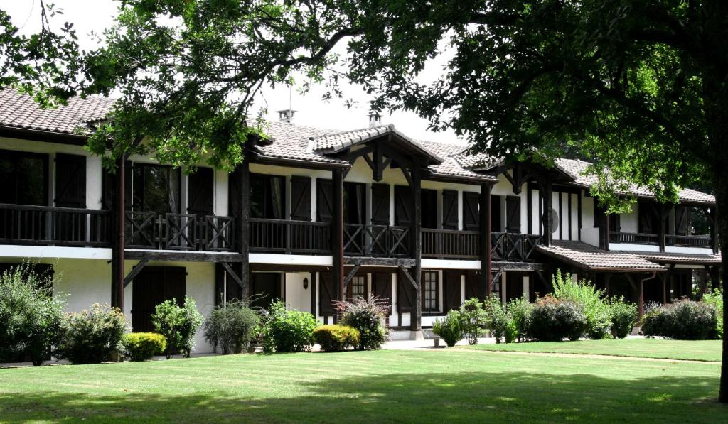 una casa grande con césped delante en Auberge des Pins - Teritoria, en Sabres