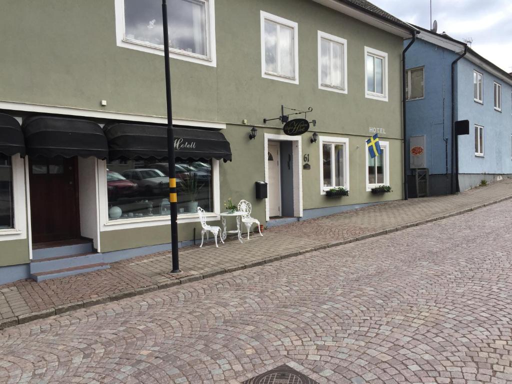 門斯特羅斯的住宿－Höjdens Lågprishotell，一条街道,在建筑前有两把白色椅子