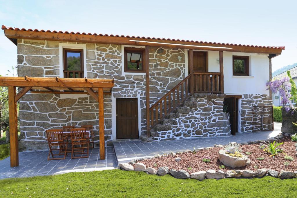 a stone house with a porch and a patio at Casa Juca in La Teijeira