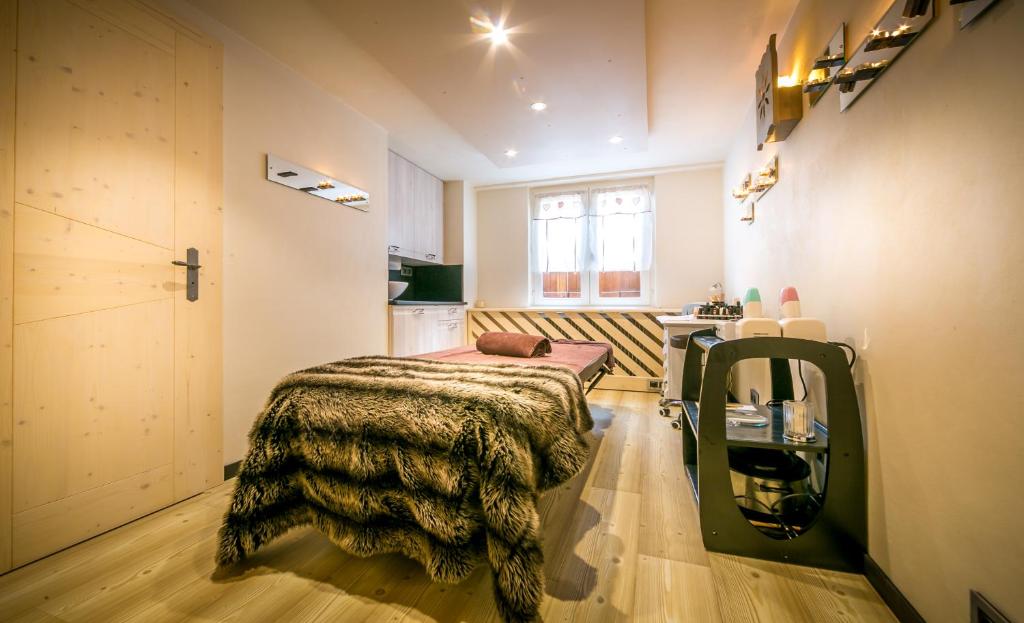a bedroom with a bed with a blanket on it at Hotel & Spa Le Dahu in Morzine
