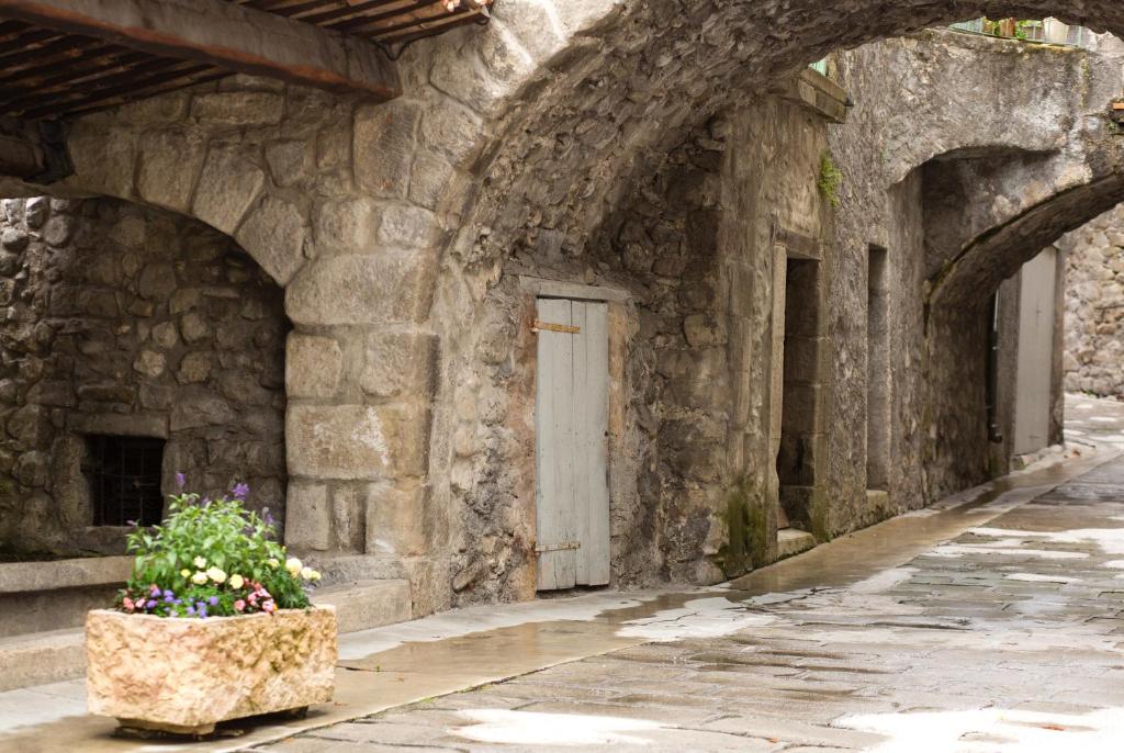 a stone building with a door and a flower pot at Le Beausejour in Annot