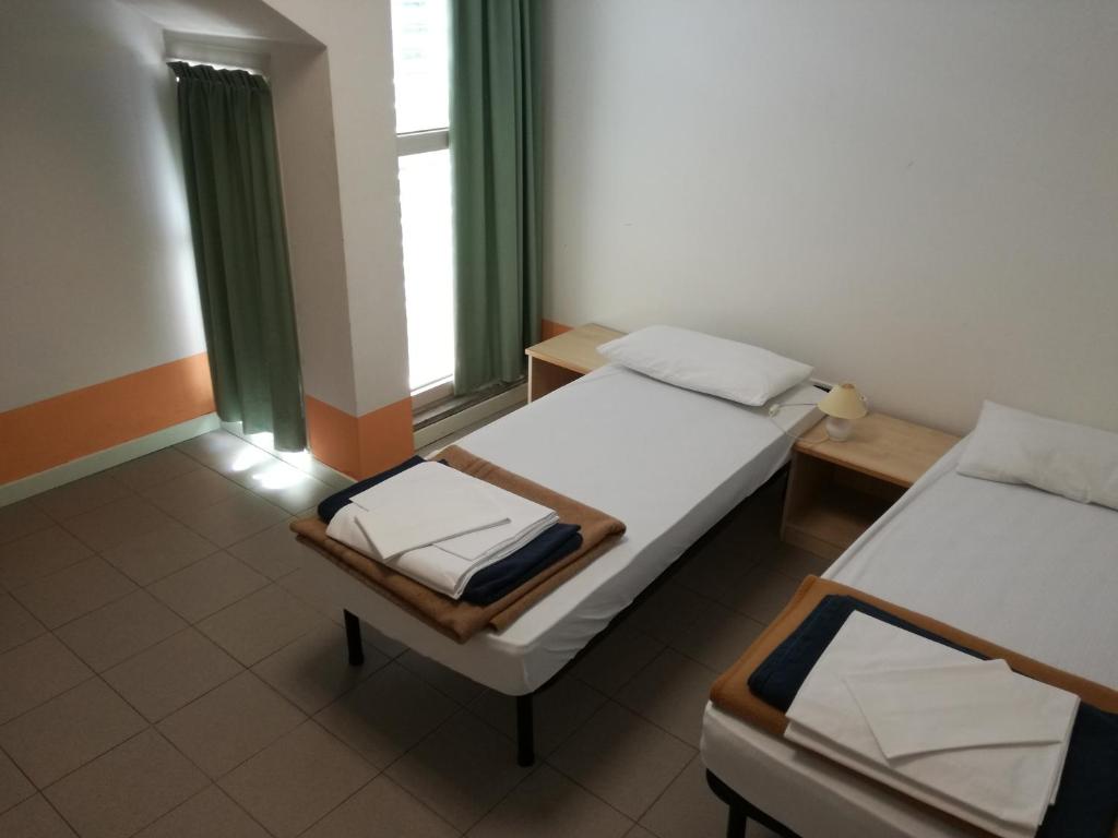 Postel nebo postele na pokoji v ubytování Ostello Domus Augusta Aquileia