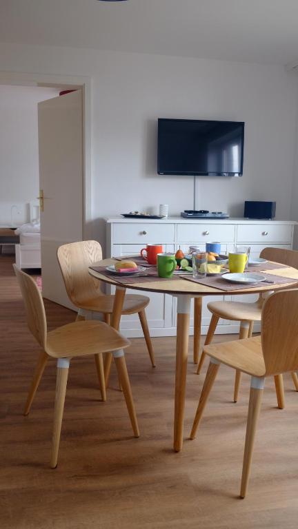 a dining room with a table with chairs and a tv at Haus am Meer-Ferienwohnungen Sylt in Hörnum