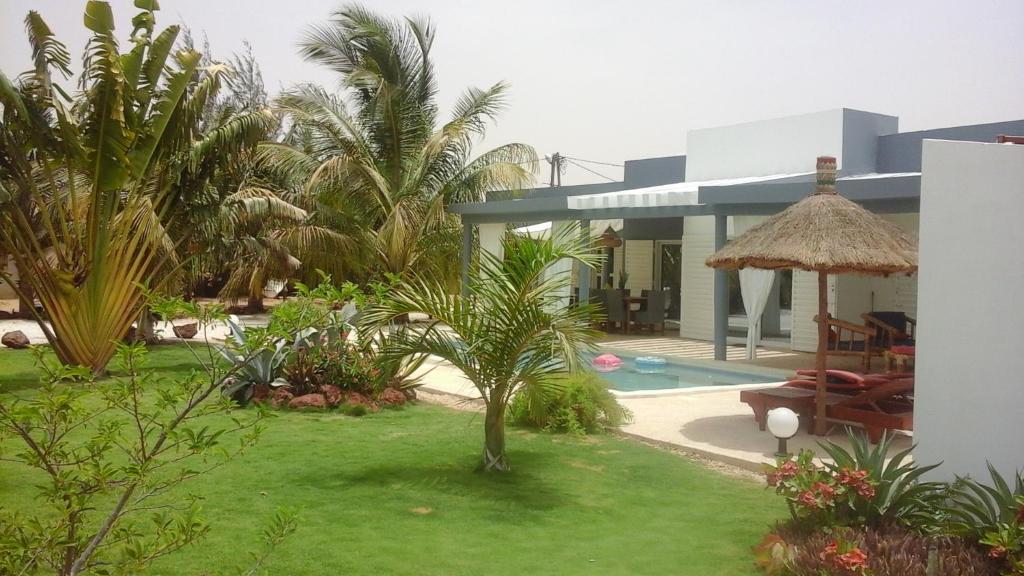 une villa avec un jardin et une piscine dans l'établissement Chambre d'hôte les vacanciers, à Nianing