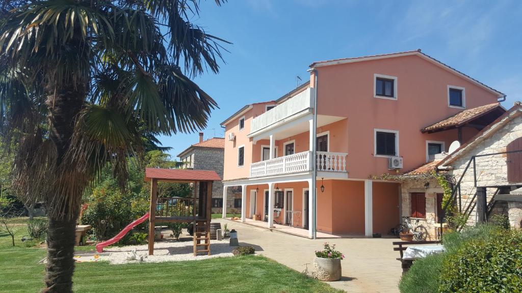 una casa con parco giochi e palma di Apartments Sorgo a Novigrad Istria