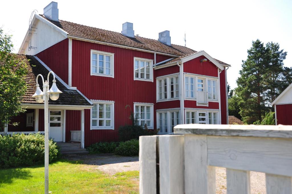 a red house with white windows and a fence at Opintola Bed & Breakfast in Norinkylä