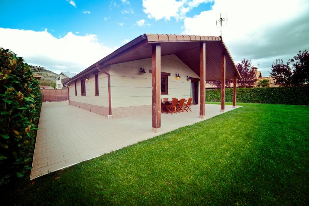 a pavilion with a roof on a lawn at El Mirador de la Toba in Fuentetoba