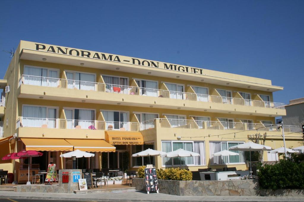 a tan building with a sign that reads panoramic inn night at Panorama in Port de Pollensa