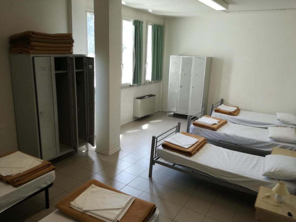 Postel nebo postele na pokoji v ubytování Ostello Domus Augusta Aquileia