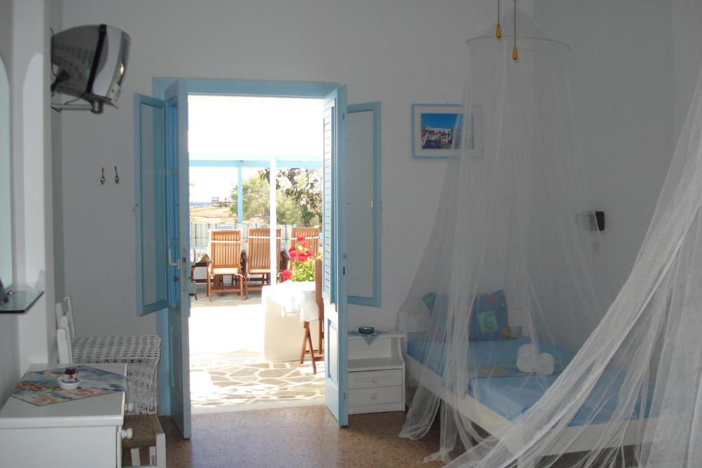 a bedroom with a bed and a door to a patio at Paroscarmel studio-apartment in Logaras