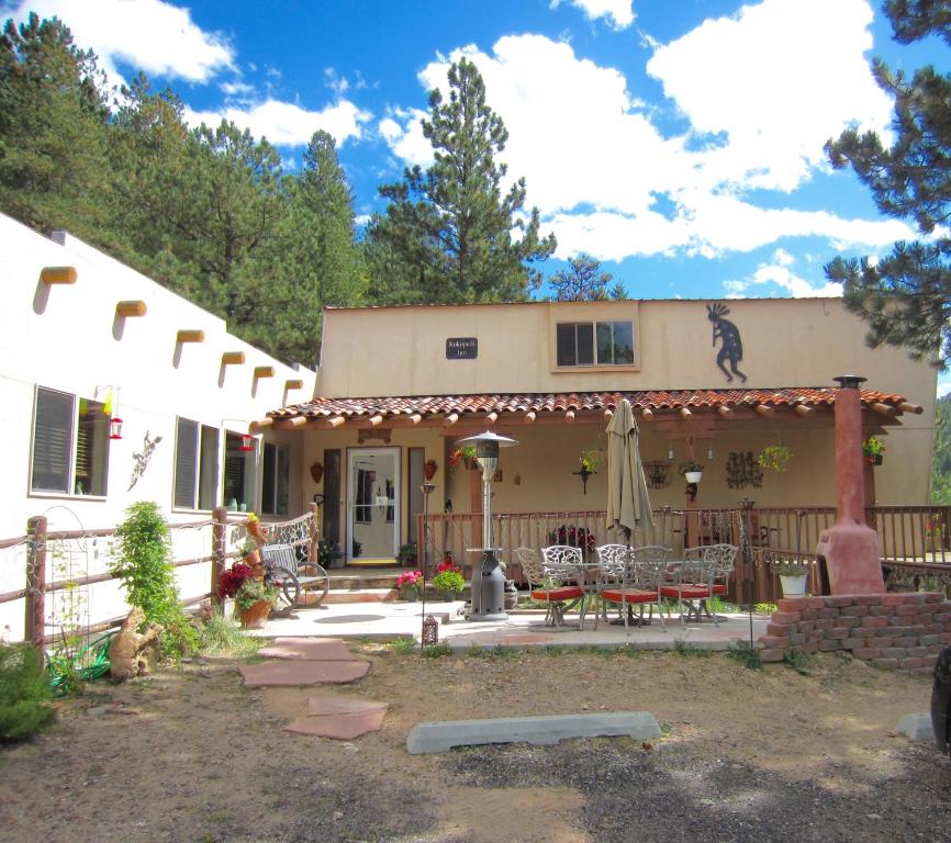 a house with a patio with chairs and an umbrella at Kokopelli Inn in Estes Park