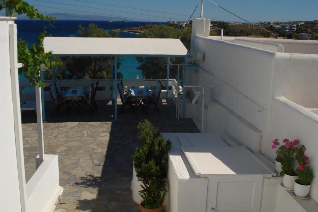 a balcony of a house with a table and chairs at Paroscarmel studio-apartment in Logaras