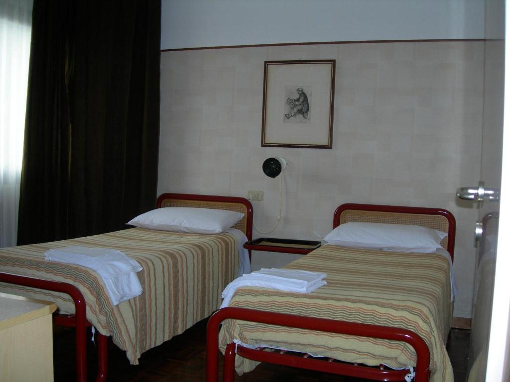 2 letti in camera d'albergo con asciugamani di Residence Antica Fonte a Boario Terme