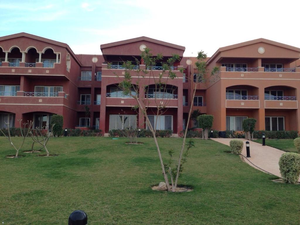 un edificio con un árbol en medio de un patio en Porto Ain Sokhna chalet with sea and pool view, en Ain Sokhna