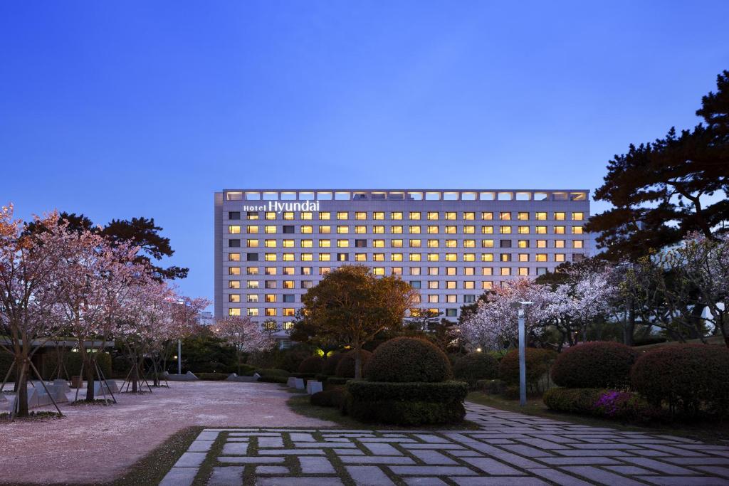 un gran edificio con un jardín delante de él en Hotel Hyundai by Lahan Ulsan, en Ulsan