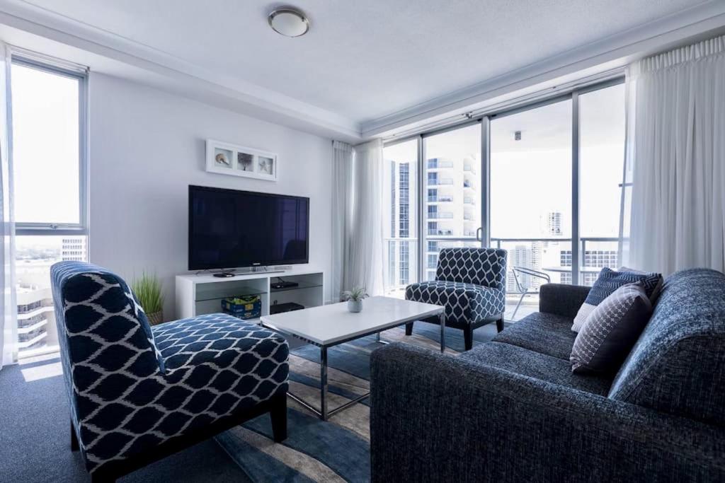 een woonkamer met een bank en stoelen en een tv bij Apartment with Ocean Views in Gold Coast