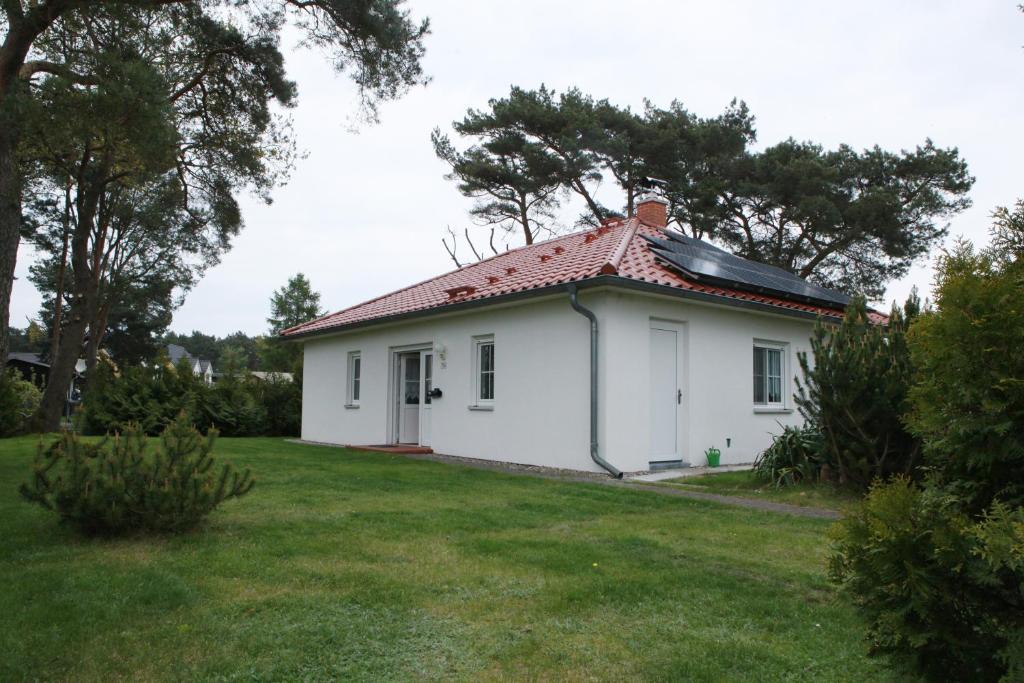 a small white house with a red roof at Ferienhaus Marleen in Pritzier