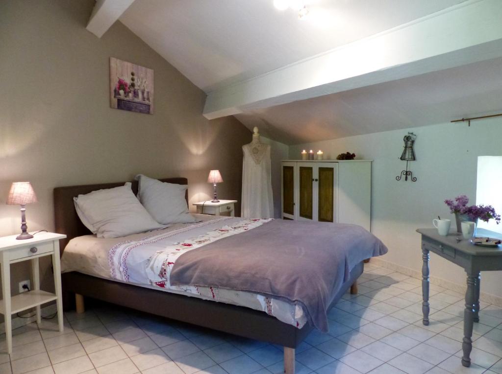 1 dormitorio con 1 cama grande y 1 mesa en Gîte de Fontainebleau en Vicdessos