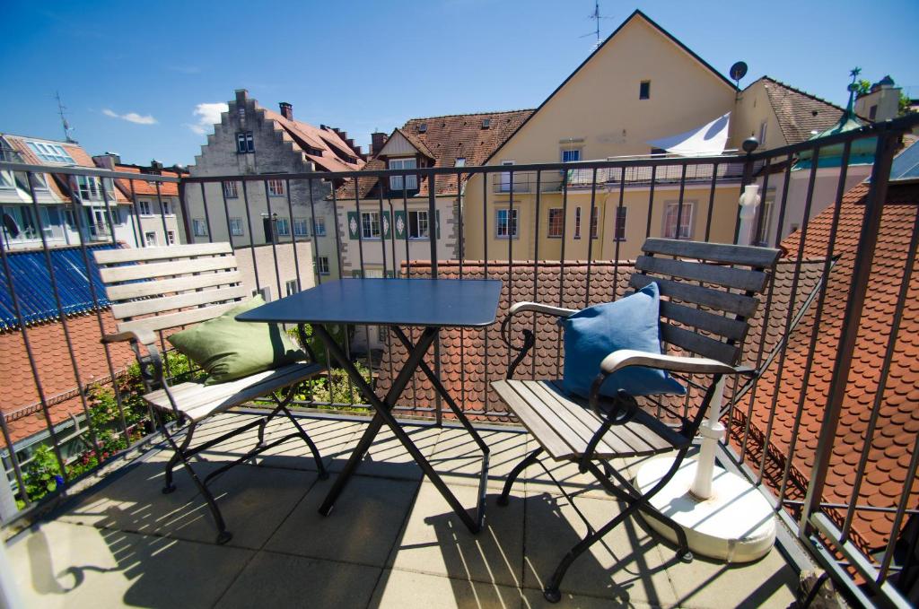uma mesa e cadeiras numa varanda com cerca em Feriendomizil "Zum Grauen Wolf" em Lindau