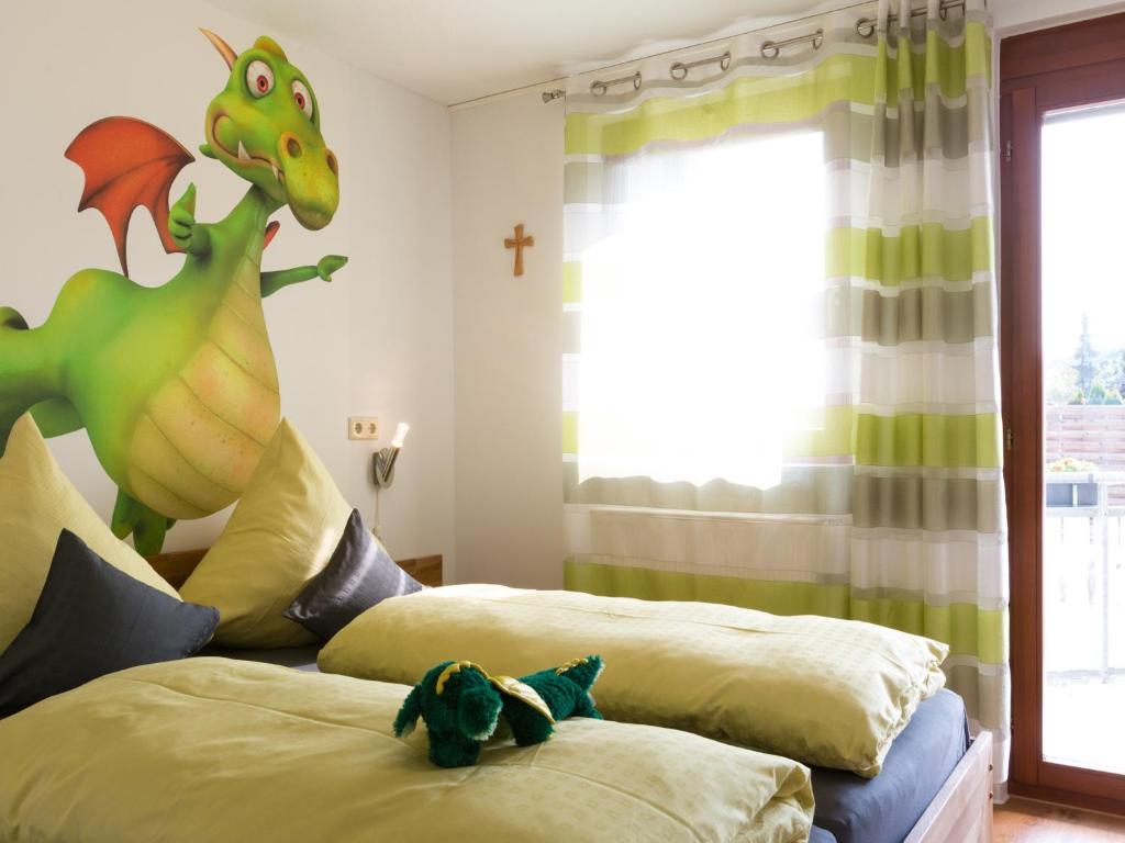 een slaapkamer met 2 bedden en een speelgoeddinosaurus erop bij Ruster Drachennest in Rust