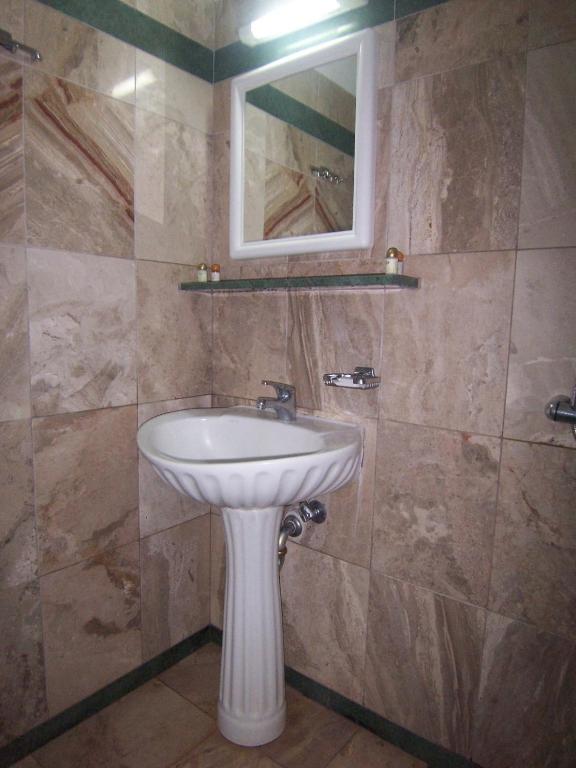 a bathroom with a white sink and a mirror at Villa Maraki in Agia Paraskevi