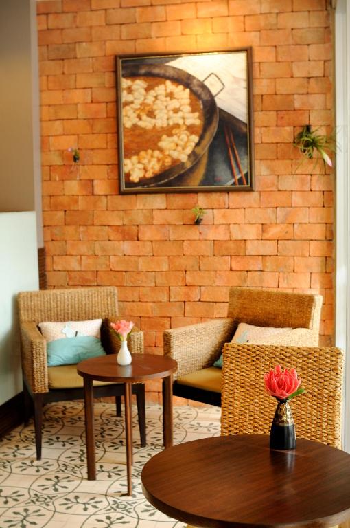 a room with two chairs and a table with a pizza at Kasemsarn Hotel Chanthaburi in Chanthaburi