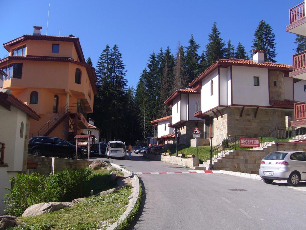 a street with houses and a car parked on the road at Snow White's Secret Chalet in the Forest in Pamporovo