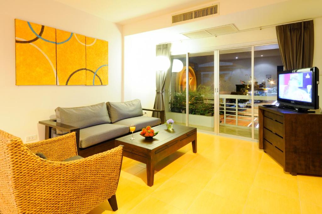 a living room with a couch and a tv at Kasemsarn Hotel Chanthaburi in Chanthaburi