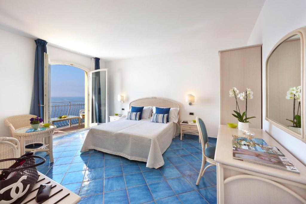 a hotel room with a bed and a balcony at Hotel Villa Pandora in Maiori