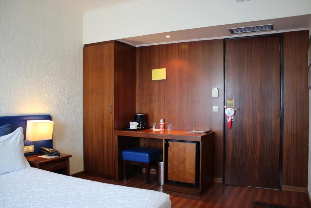 A hotel bedroom corner with a narrow built-in desk, coffee station and wardrobe.