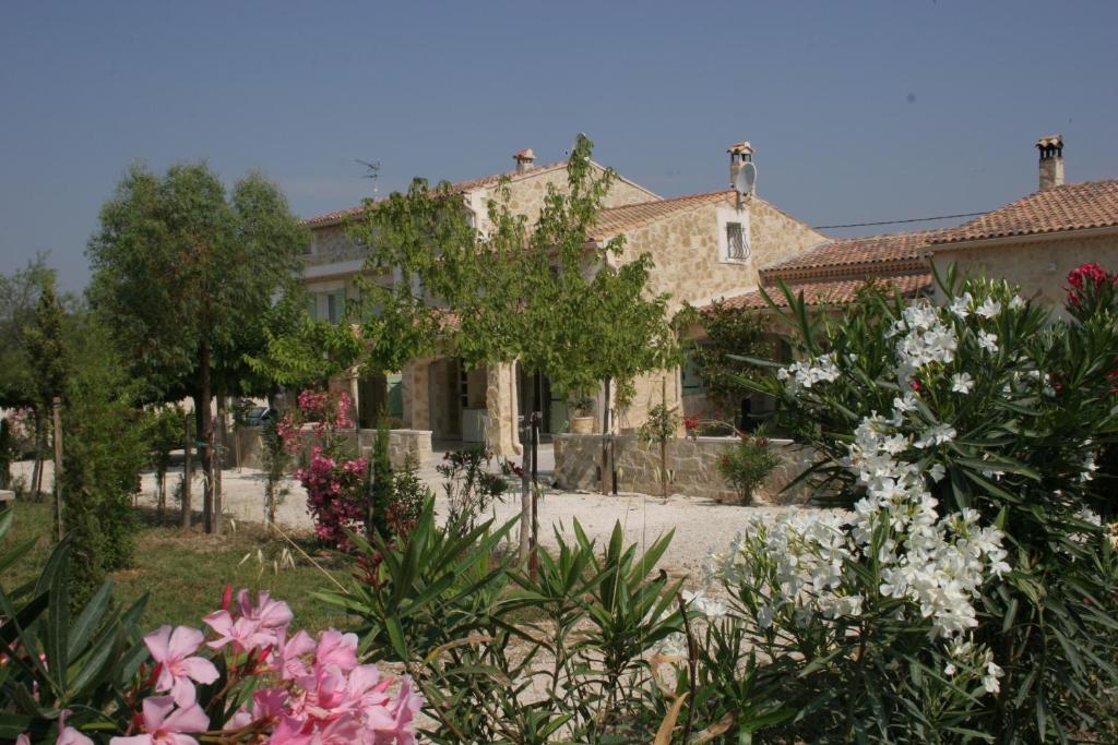 a garden with flowers in front of a building at Locations des Alpilles in Saint-Rémy-de-Provence