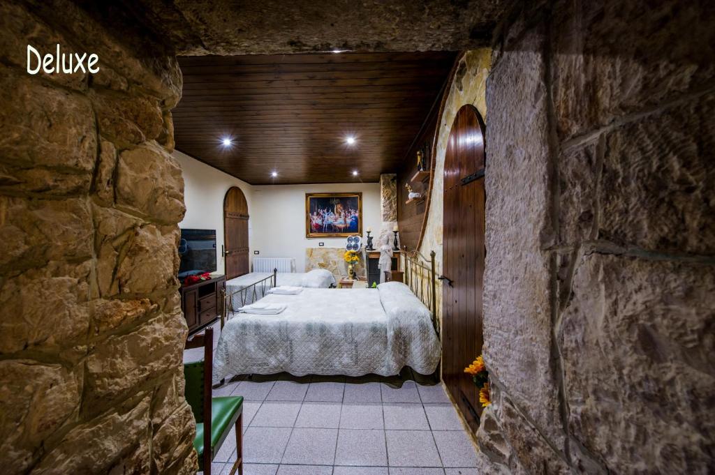 a bedroom with a large bed in a stone wall at La Cutizza B&B in Martina Franca