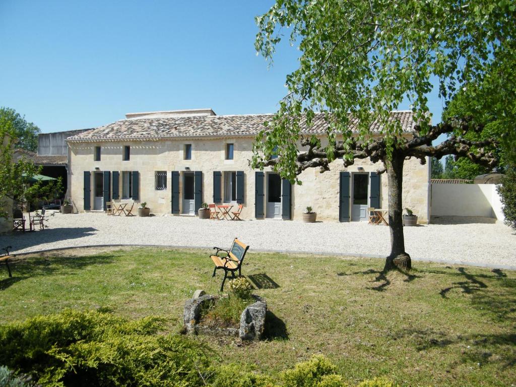 un edificio con un banco frente a un patio en Clos Vieux Rochers Vineyard en Puisseguin