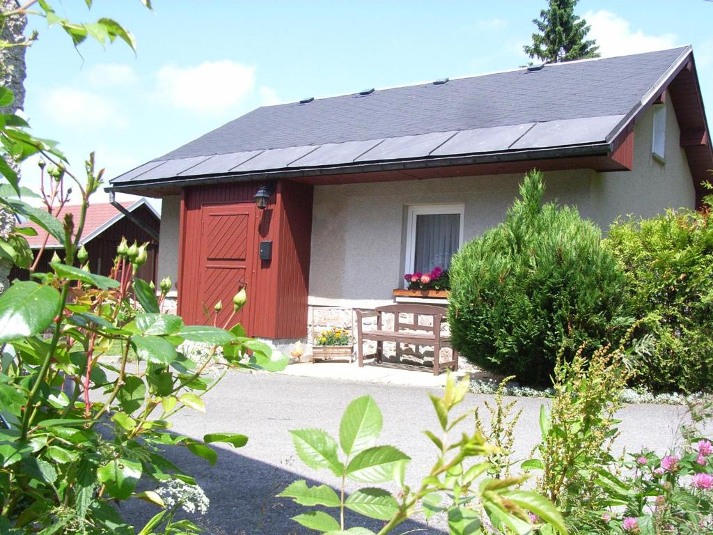 Casa pequeña de color rojo y blanco con porche en Ferienhaus Brigitte en Klingenthal