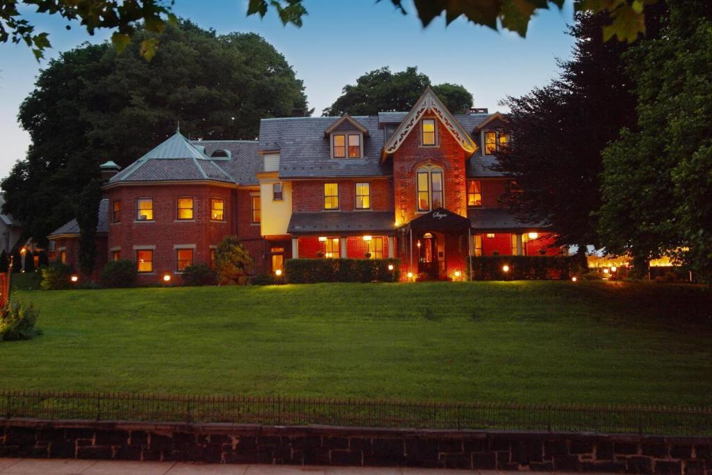 una casa grande en el césped por la noche en The Sayre Mansion, en Bethlehem