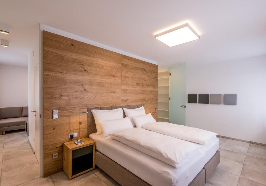 a bedroom with a bed with a wooden wall at 24/7 Zimmer Asten in Asten