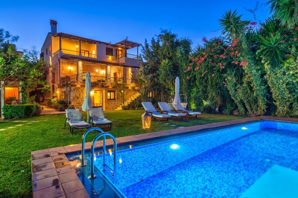 a backyard with a swimming pool and a house at Villa Arhontariki in Kissamos