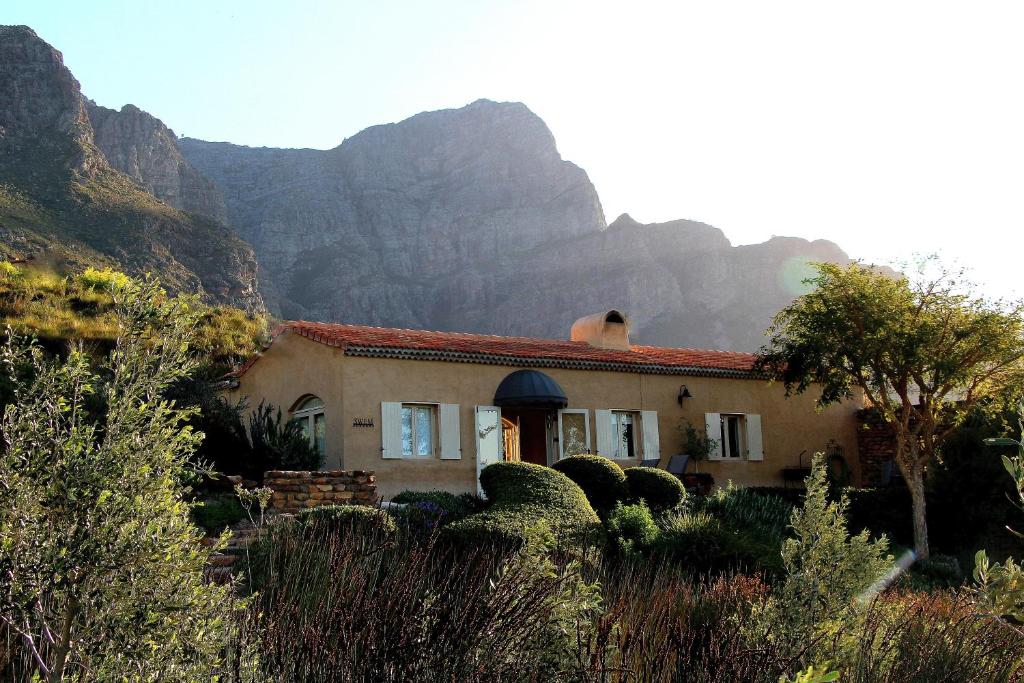 a house with a mountain in the background at The Cottage @ Montpellier in Franschhoek