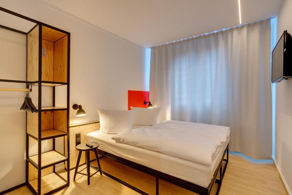 Postel nebo postele na pokoji v ubytování MEININGER Hotel Leipzig Hauptbahnhof