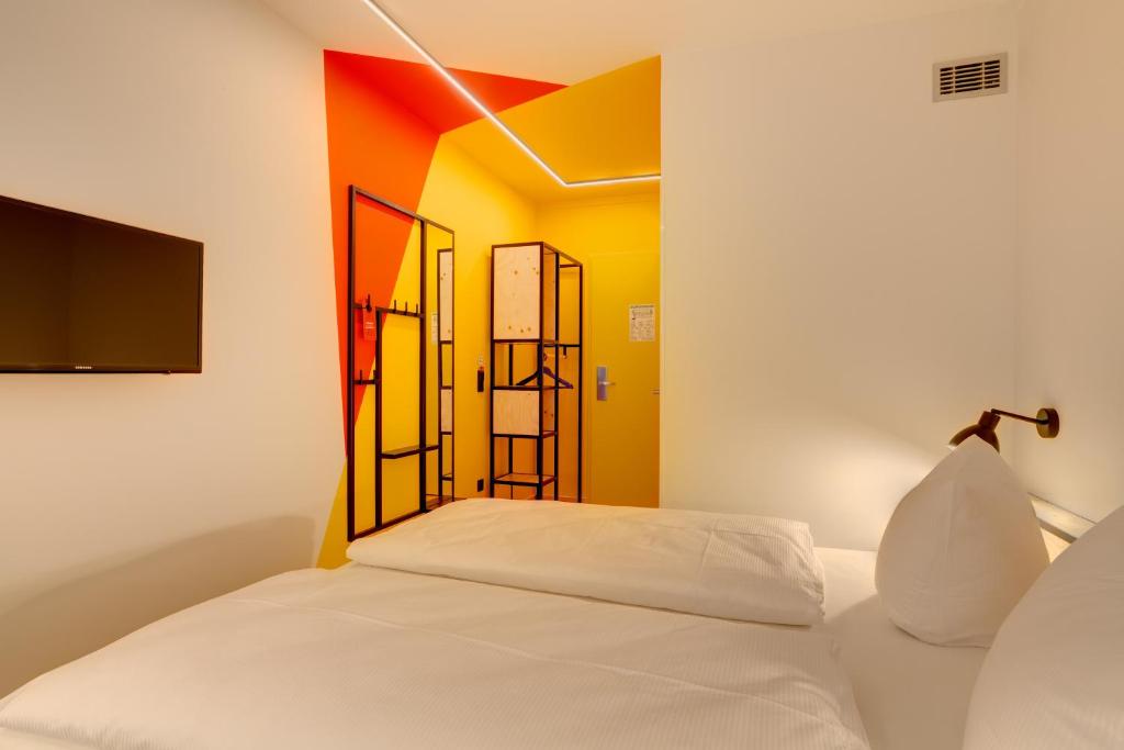 Postel nebo postele na pokoji v ubytování MEININGER Hotel Leipzig Hauptbahnhof