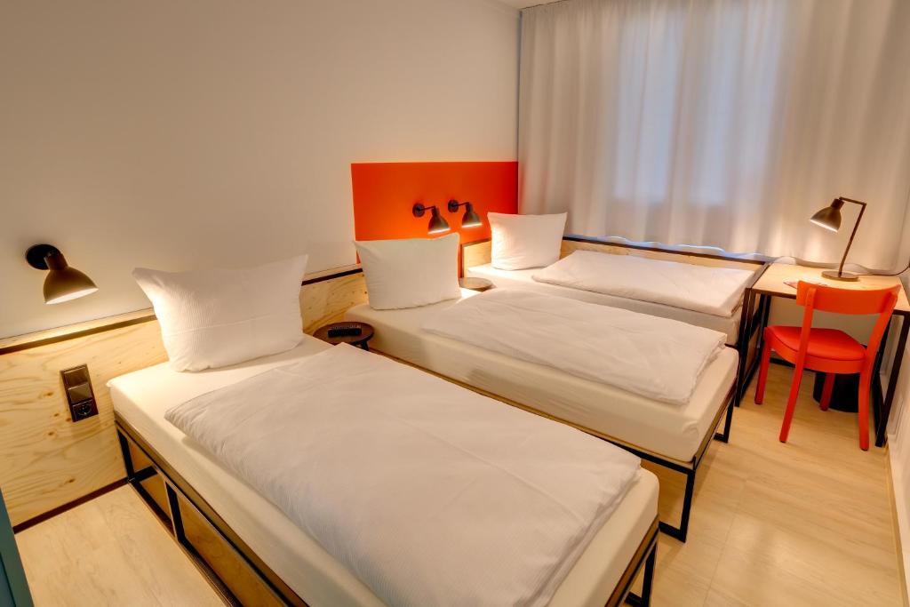 Postel nebo postele na pokoji v ubytování MEININGER Hotel Leipzig Hauptbahnhof