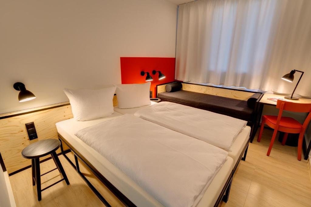 Postel nebo postele na pokoji v ubytování MEININGER Hotel Leipzig Hauptbahnhof