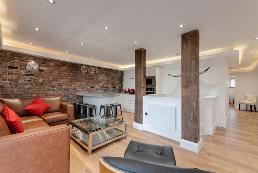 a large living room with a couch and a kitchen at The Picture House Apartments in Liverpool