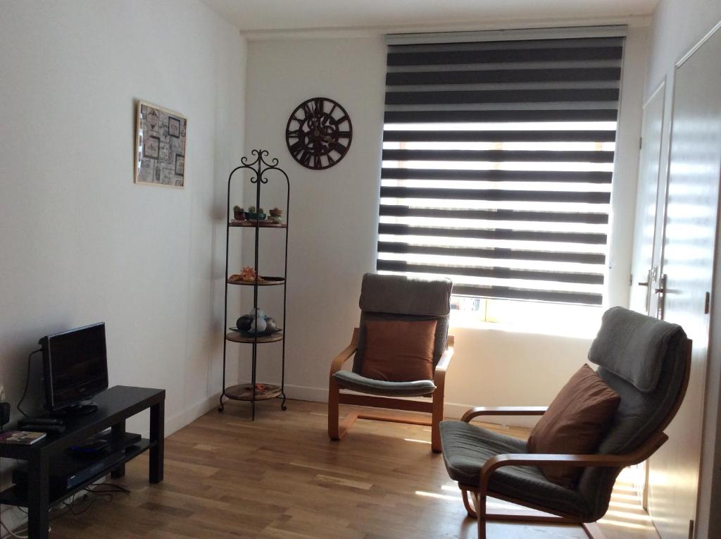 una sala de estar con 2 sillas y una ventana con persianas en Number 7 Gouarec, en Gouarec