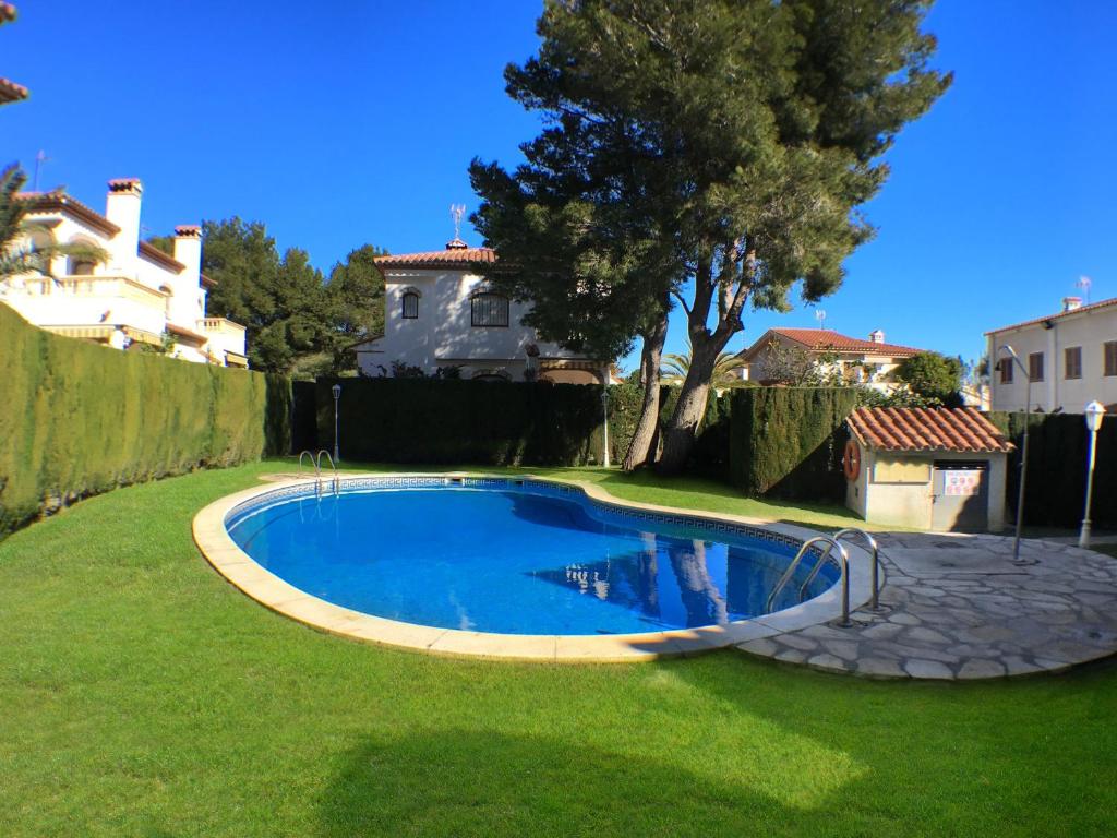 a swimming pool in a yard next to a house at ARENDA Pino Alto Holiday Home Rioja in Miami Platja
