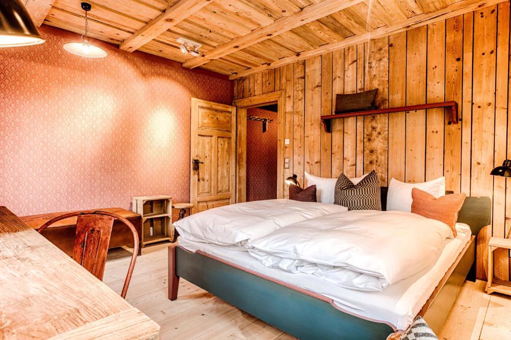 a bedroom with a bed in a room with wooden walls at Bio-Hotel Zur Mühle in Bad Schandau