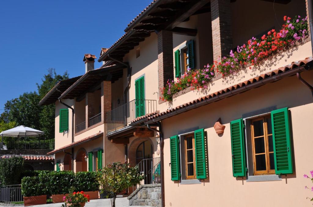 a building with green shutters and flowers on it at Casa Albinelli in Cutigliano