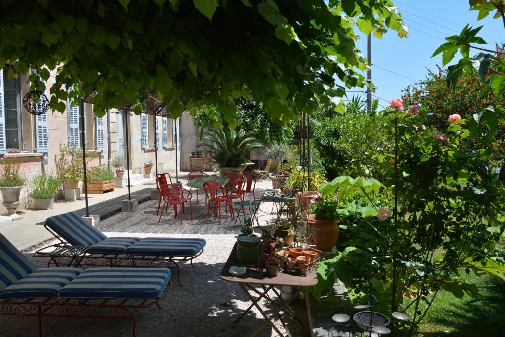a patio with chairs and a table with plants at Les Passiflores in Grasse
