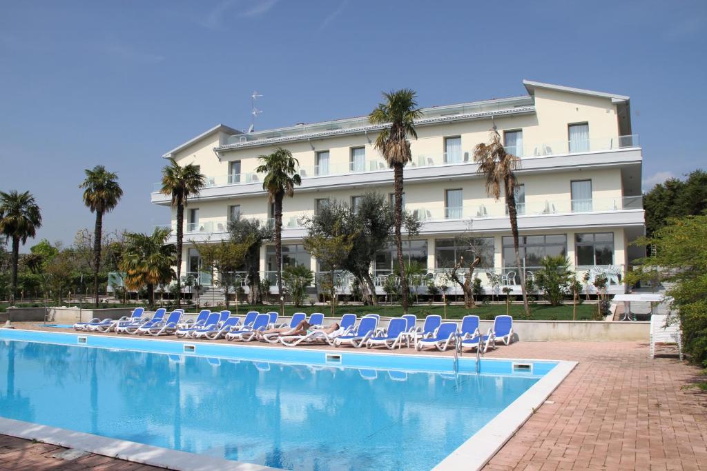 a hotel with chairs and a swimming pool at Front Lake Hotel Villa Paradiso Suite in Moniga